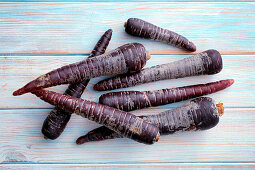 Purple carrots on a wooden background