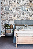 Double bed with bed headboard and bedside table in front of silver-gray wallpaper