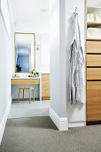 View into walk-in wardrobe, dressing table in the bathroom ensuite in the background