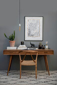 Wooden chair and desk against grey wall