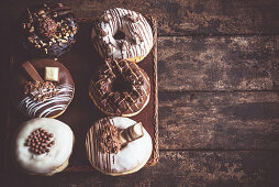 Brown and white glazed donuts on a wooden background