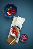 Muesli with yoghurt, pomegranate seeds, blueberries and raspberries (top view)