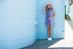 Mädchen mit Sommerhut in blau-weiß bedrucktem Sommerkleid