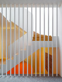 Weiß gestrichene Metallstangen als Raumteiler, Blick auf Treppenhaus
