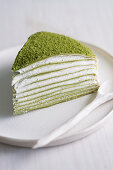 A piece of Mille Crepes cake (pancake cake) with matcha and cream filling