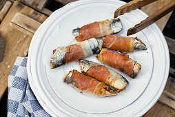 Stuffed, grilled sardines wrapped in bacon
