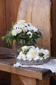 Bouquet of anemones, carnation and ivy next to basket of onions