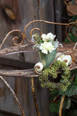 Posy and heart-shaped wreath of ivy berries on old metal table
