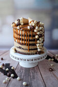 A popcorn drip cake with peanut butter cream and caramel