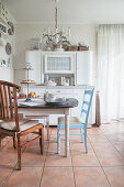 Dining area in front of old white dresser in Nordic-style kitchen