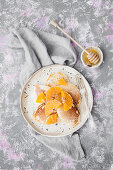 Pancakes served with oranges and honey