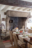 Set dining table in front of old open fireplace