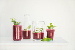 Fresh morning beetroot smoothie or juice in glasses with mint, white background, copy space