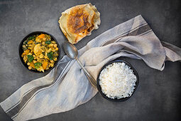 Vegetable curry with cauliflower, butternut squash, spinach and coriander served with poppadoms and rice