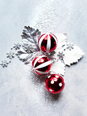 Red and white Christmas baubles on silver leaves