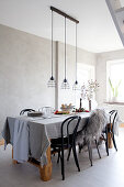 Set table in dining room in wintry shades with grey wall