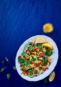 Salad with shrimp, avocado, spinach, pomegranate seeds and lemon dressing
