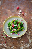 Salad with broccoli stems, radishes, pomegranate and green asparagus