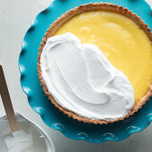 Making a lemon meringue tart: spread egg whites over the lemon cream