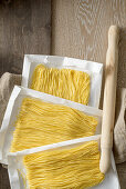 Maccheroncini di Campofilone (dünne Eierspaghetti)auf Papier zum Trocknen