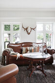 Hunting trophy on wall above leather sofa in classic living room