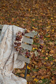 Handmade circlet of horse chestnuts and blanket on garden chair