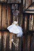 DIY-Engel mit weißen Häkelkleidchen an Holztür