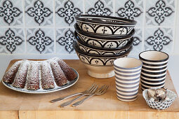 Advocaat cake, bowls and beakers on wooden surface