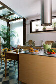 Extractor hood above island counter, kitchen table and yellow chair