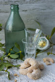 Vanilla crescent biscuits, shot glasses and damson water in a green bottle