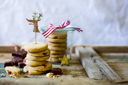 Stack of festive turkish delight biscuits with reindeer decoration as a gift with white background and wood