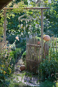 Mobile made from coat hanger wrapped in white heather above garden gate