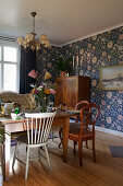 Various old furnishings and blue wallpaper in dining room