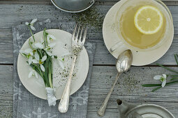 A place setting with snowdrops and a cup of bergamot tea
