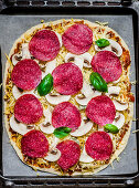 Pizza mit Salami und Champignons, ungebacken