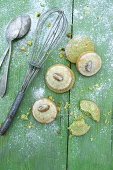 Iced pistachio biscuits on a green wooden surface