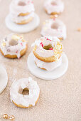 Donuts with pink icing decorated with pink sprinkles and gold leaf