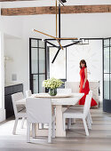 Dining area with designer lamps, woman in red dress in background