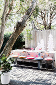 A table laid for Christmas with a wooden bench on a sunny terrace