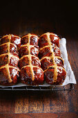 Chocolate hot cross buns with spelt on a cooling rack (vegan)