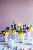 Frühlingsblumen in drei Vasen in Form zerdrückter Dosen