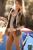 A young woman wearing an outfit in natural shades pouring tea