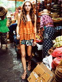 A brunette woman wearing a top and a short skirt at a market