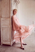 A blonde woman wearing a romantic, delicate pink dress