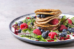 Vegane Kichererbsen-Pancakes auf Salat mit Rote-Bete-Blättern, Sprossen und Beeren