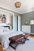 Leather stools at foot of bed in white-and-grey bedroom