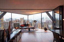 Modern living room with panoramic city view through glass walls