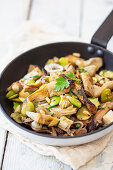 Oyster mushrooms, artichoke hearts and lima beans in frying pan