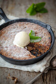 Chocolate chip cake with vanilla ice cream in a cast iron pan
