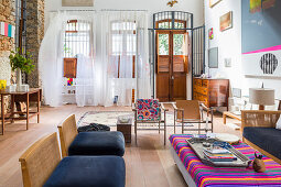Künstlerisches Wohnzimmer mit drei großen offenen Terrassentüren